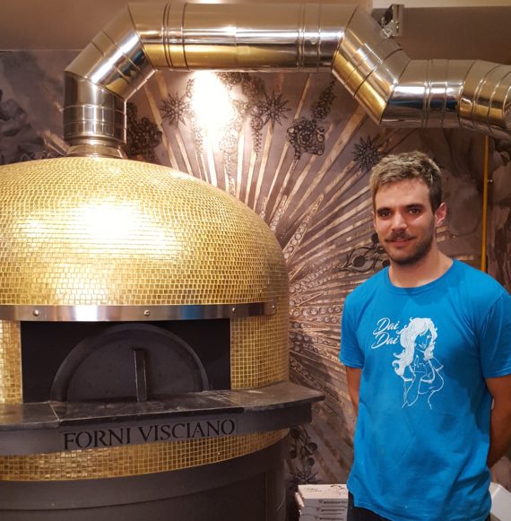 Le chef du Daï-Daï devant son four à pizza couvert de mosaïques