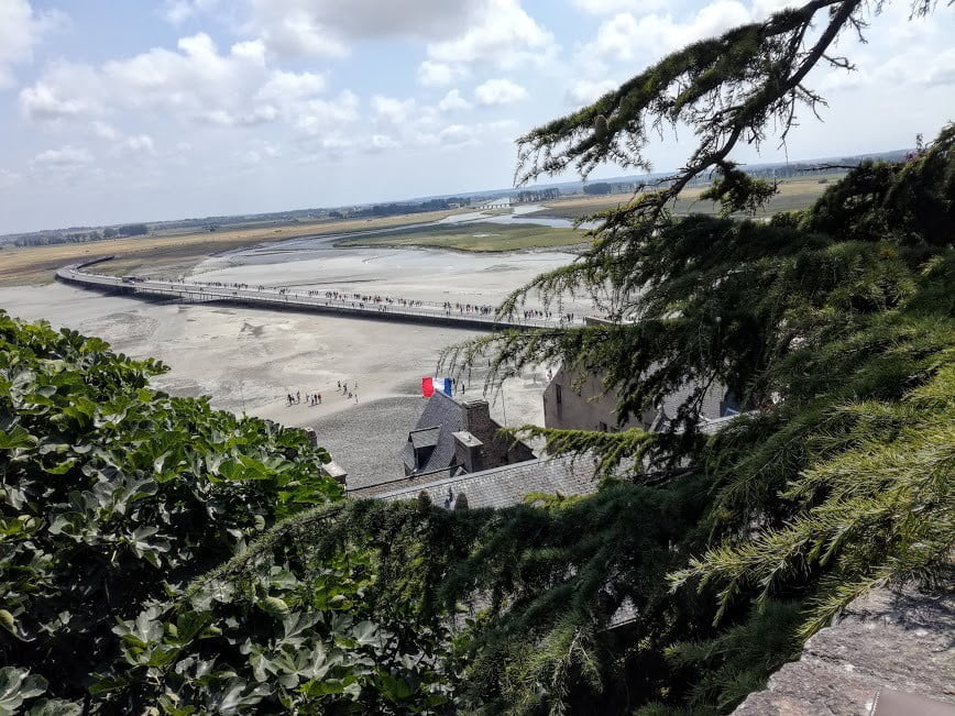 Du Mont-Saint-Michel, on voit le Couesnon, l’un des 3 fleuves de la baie canalisé et régulé par un barrage. L’ancienne digue d’accès au Mont, détruite, est remplacée aujourd’hui par une passerelle au-dessous de laquelle la mer a libre accès.